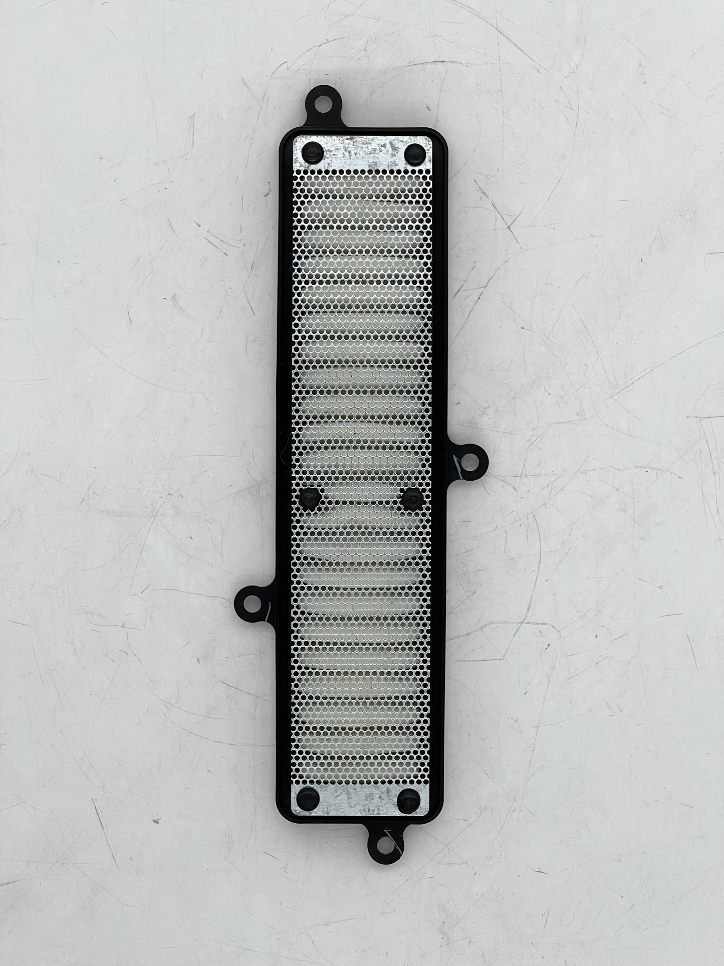 Metallic radiator guard on a textured white background