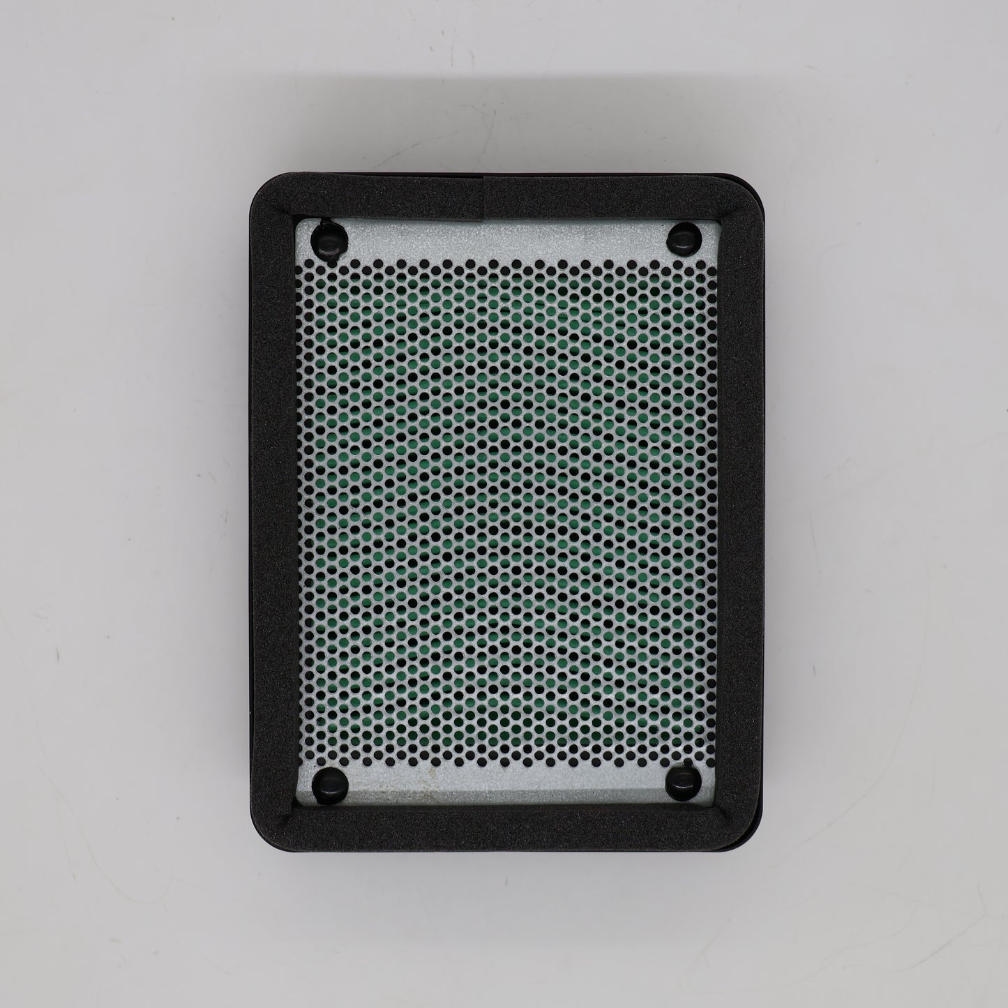 A rectangular black speaker grille cover with rounded corners, featuring a silver metal mesh center and four mounting holes, shown from a top-down view on a light gray background.