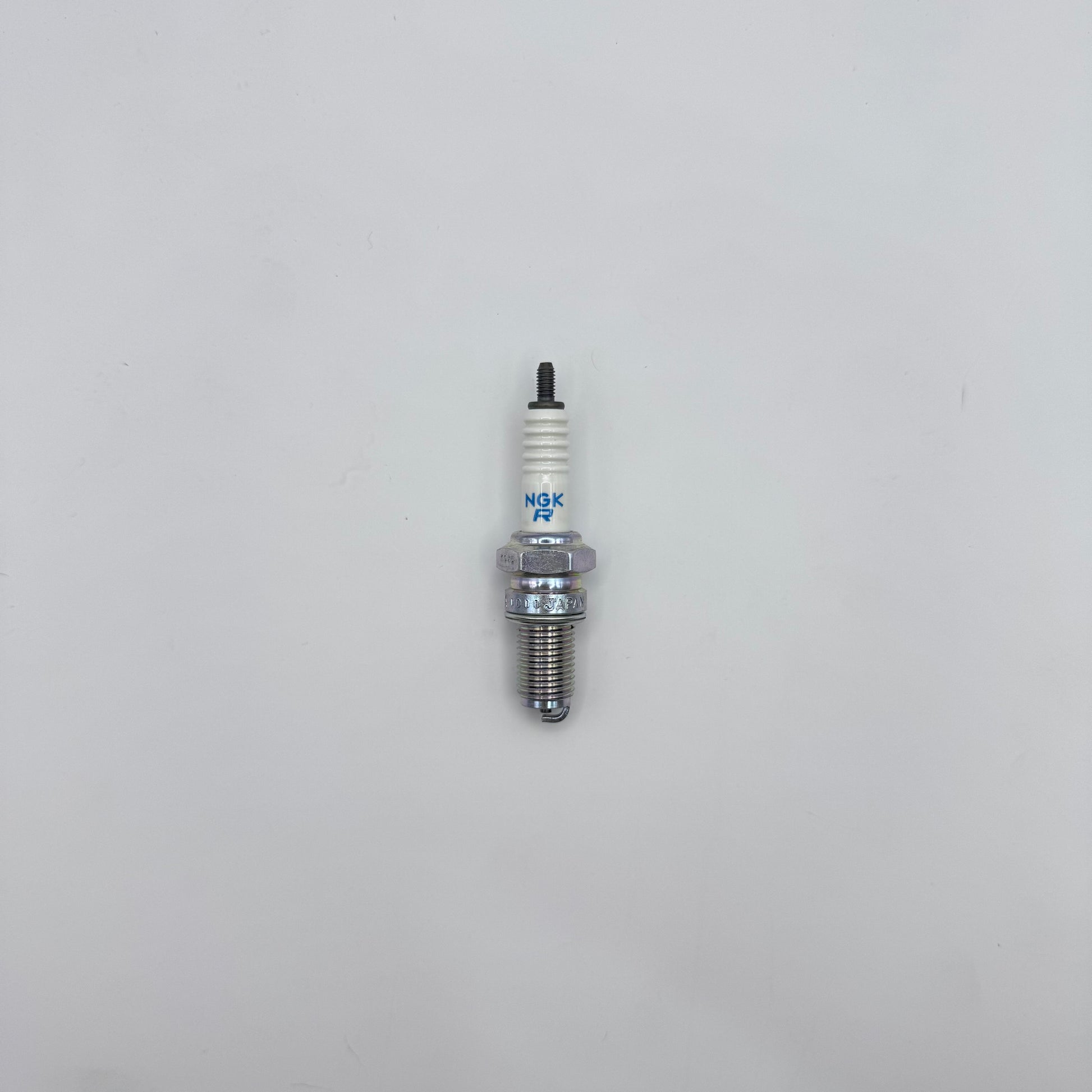 Spark plug on a light gray background