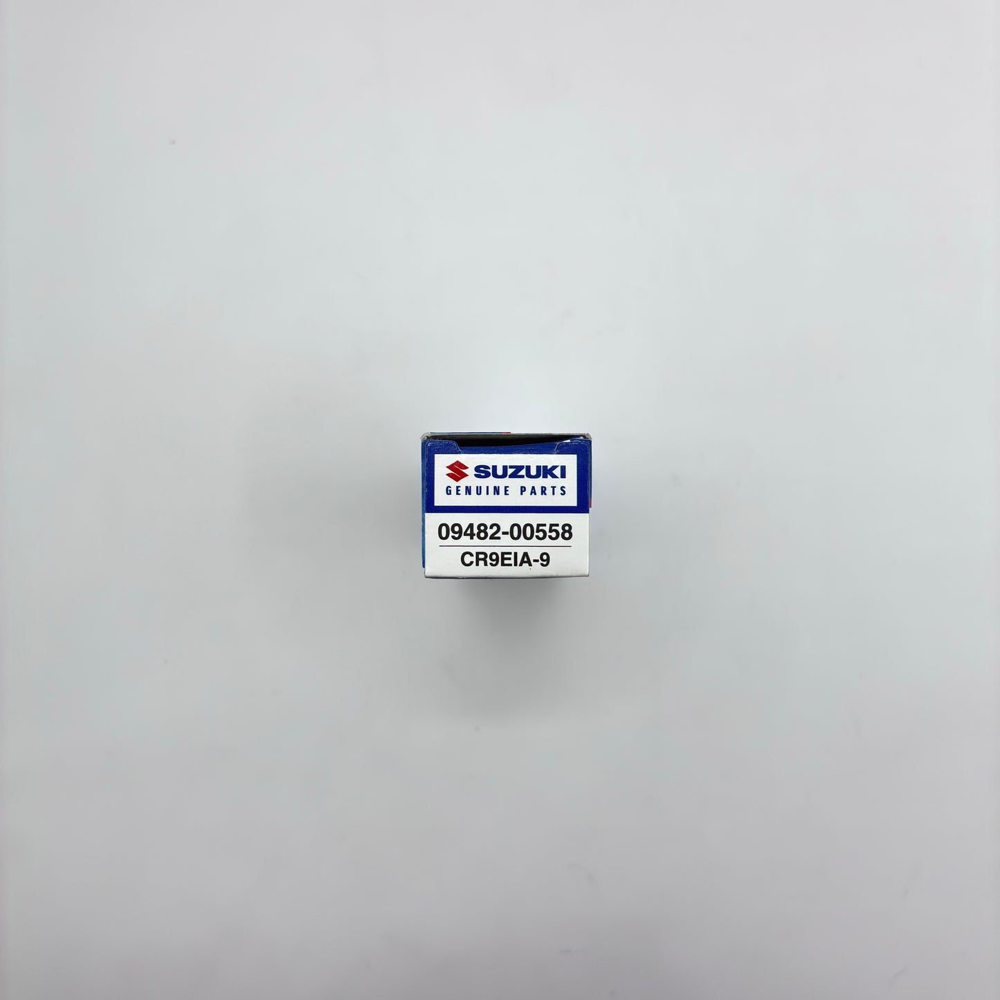 Suzuki genuine parts box with a label on a gray background