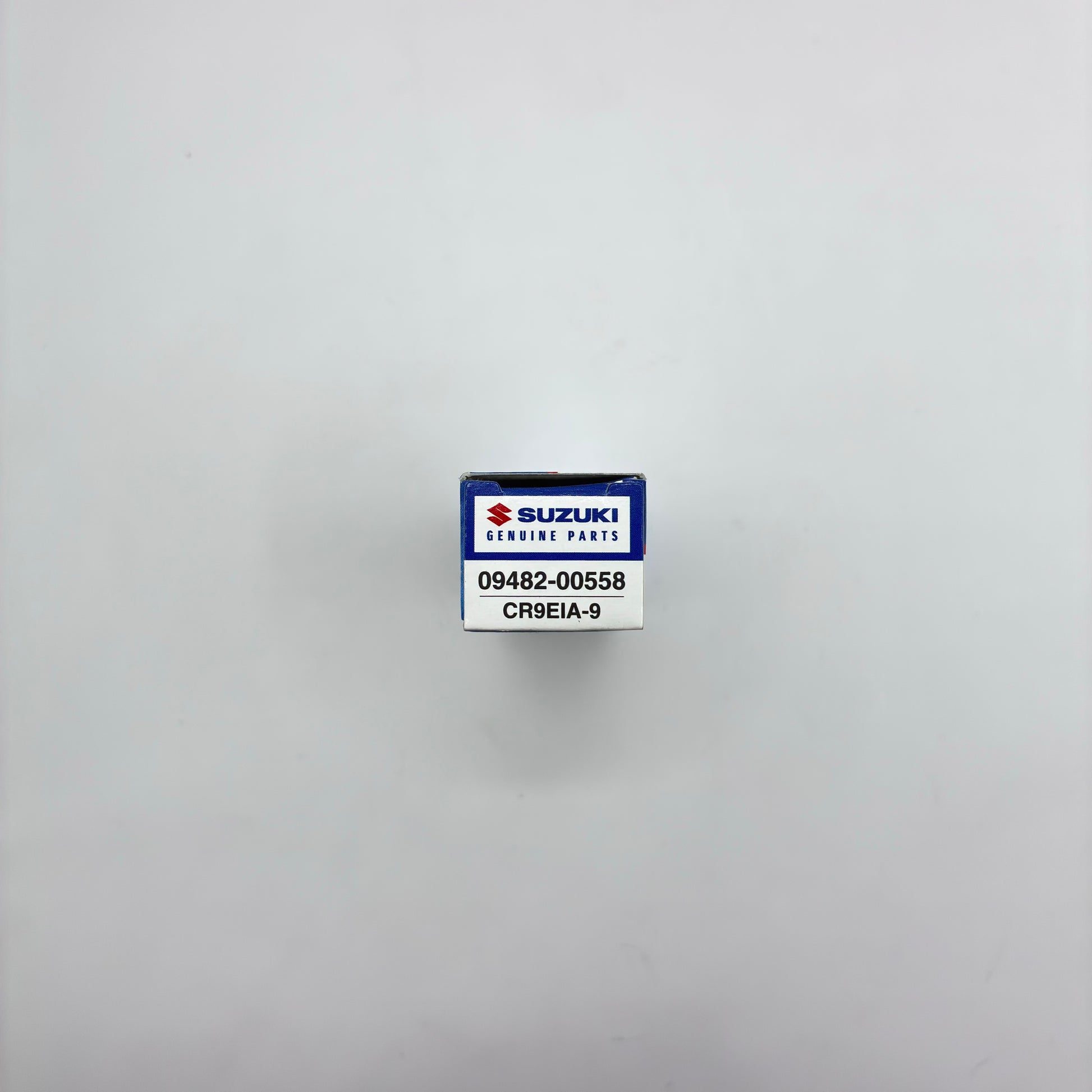 Suzuki genuine parts box with a label on a gray background