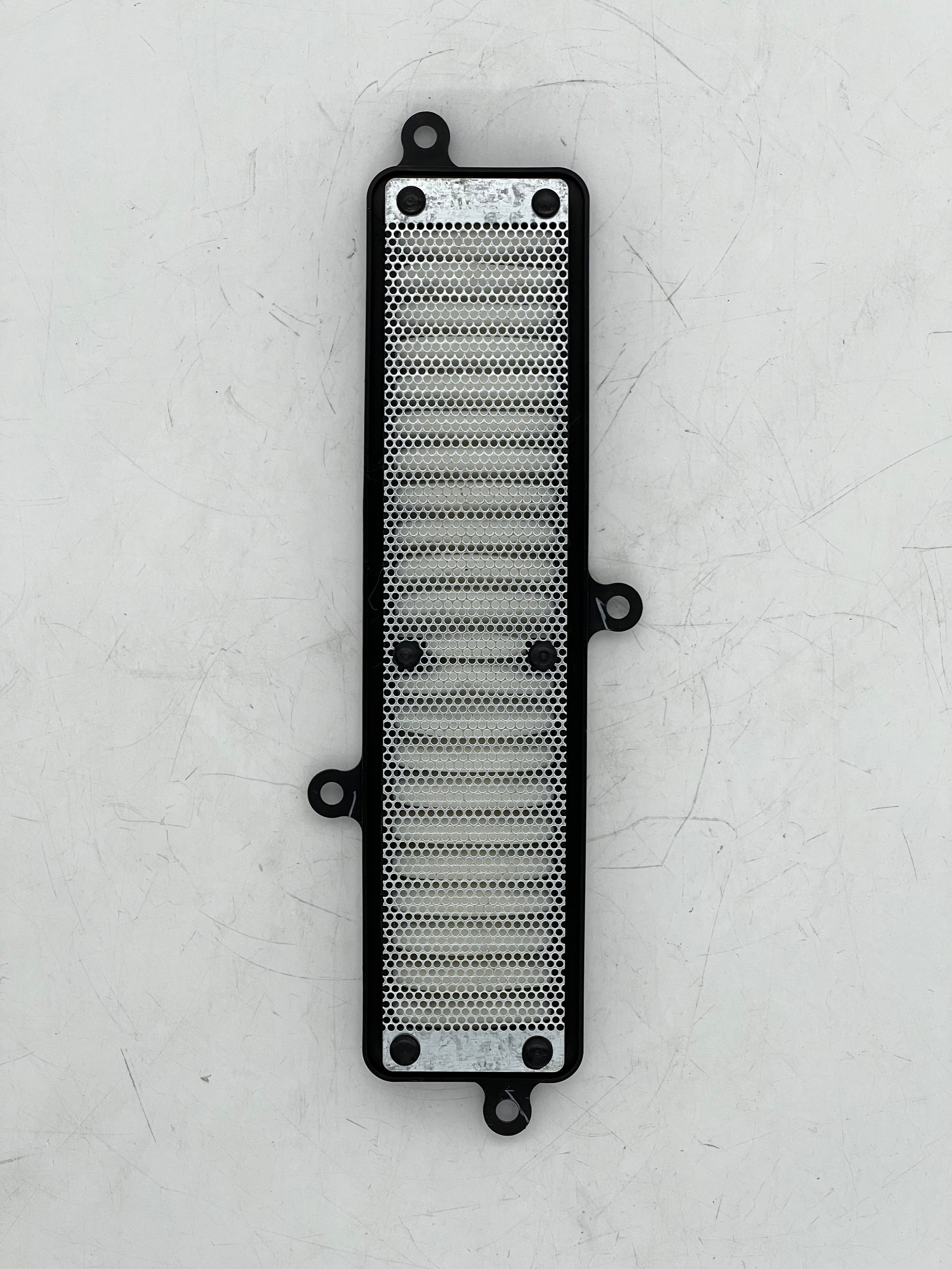 Metallic radiator guard on a textured white background