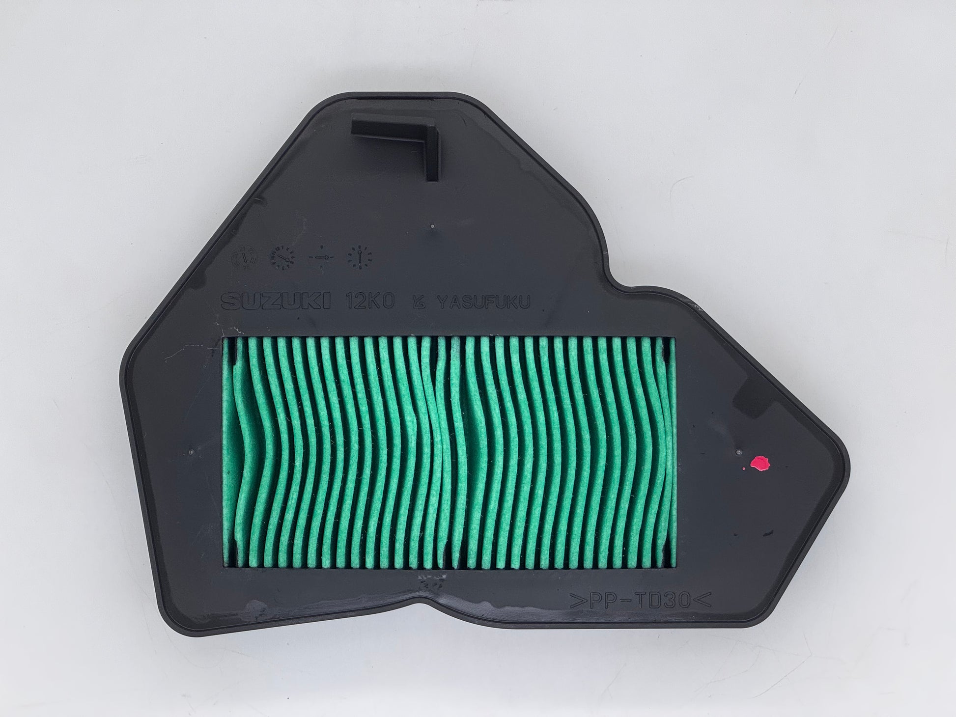 Green air filter in a black housing on a white background