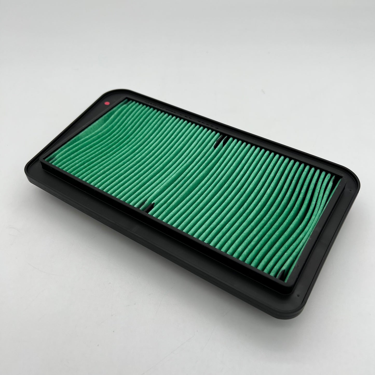 Green air filter in a black frame on a white background