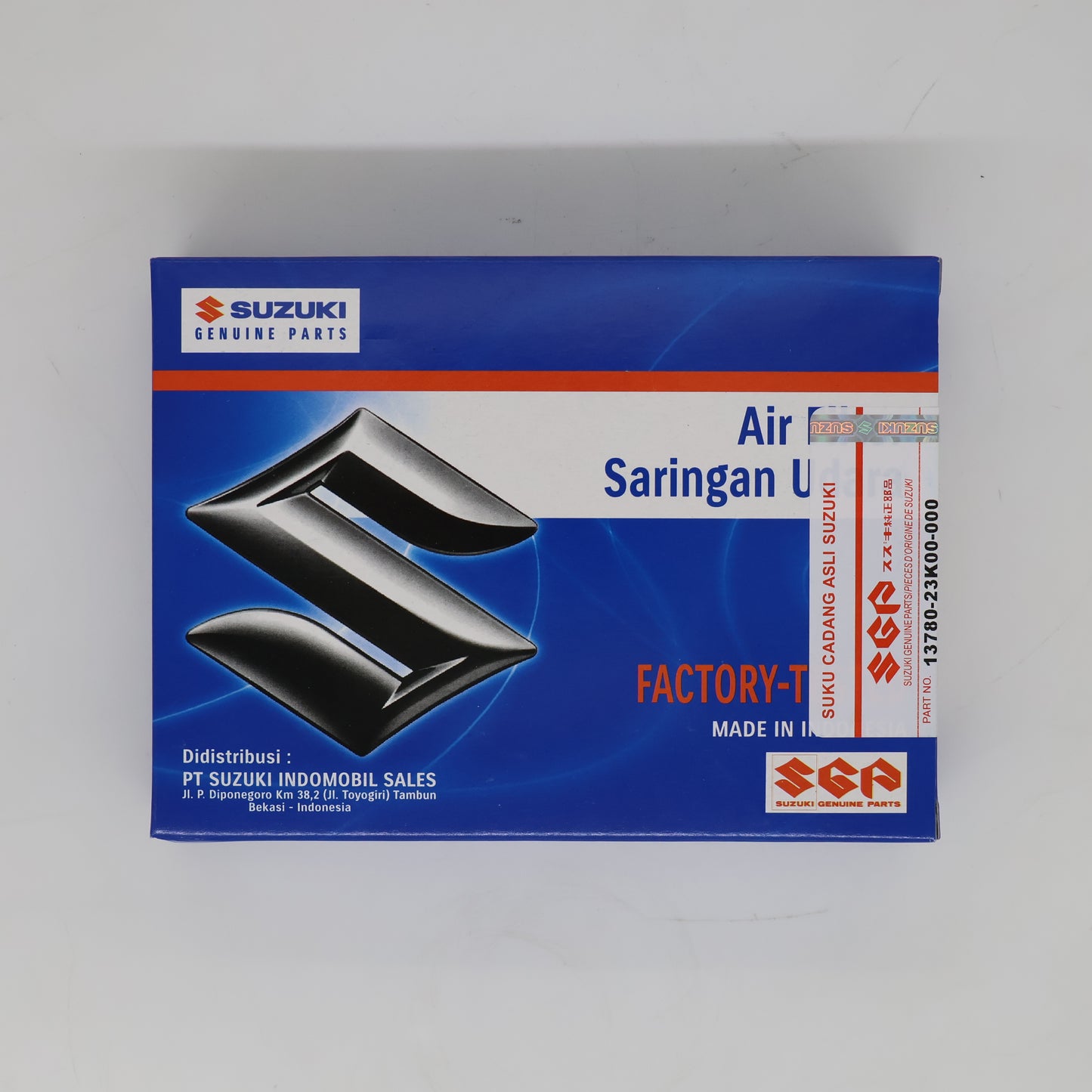 Suzuki Genuine Parts air filter box, model Saringan L, featuring a blue and white design with a black stylized engine logo and red accents.