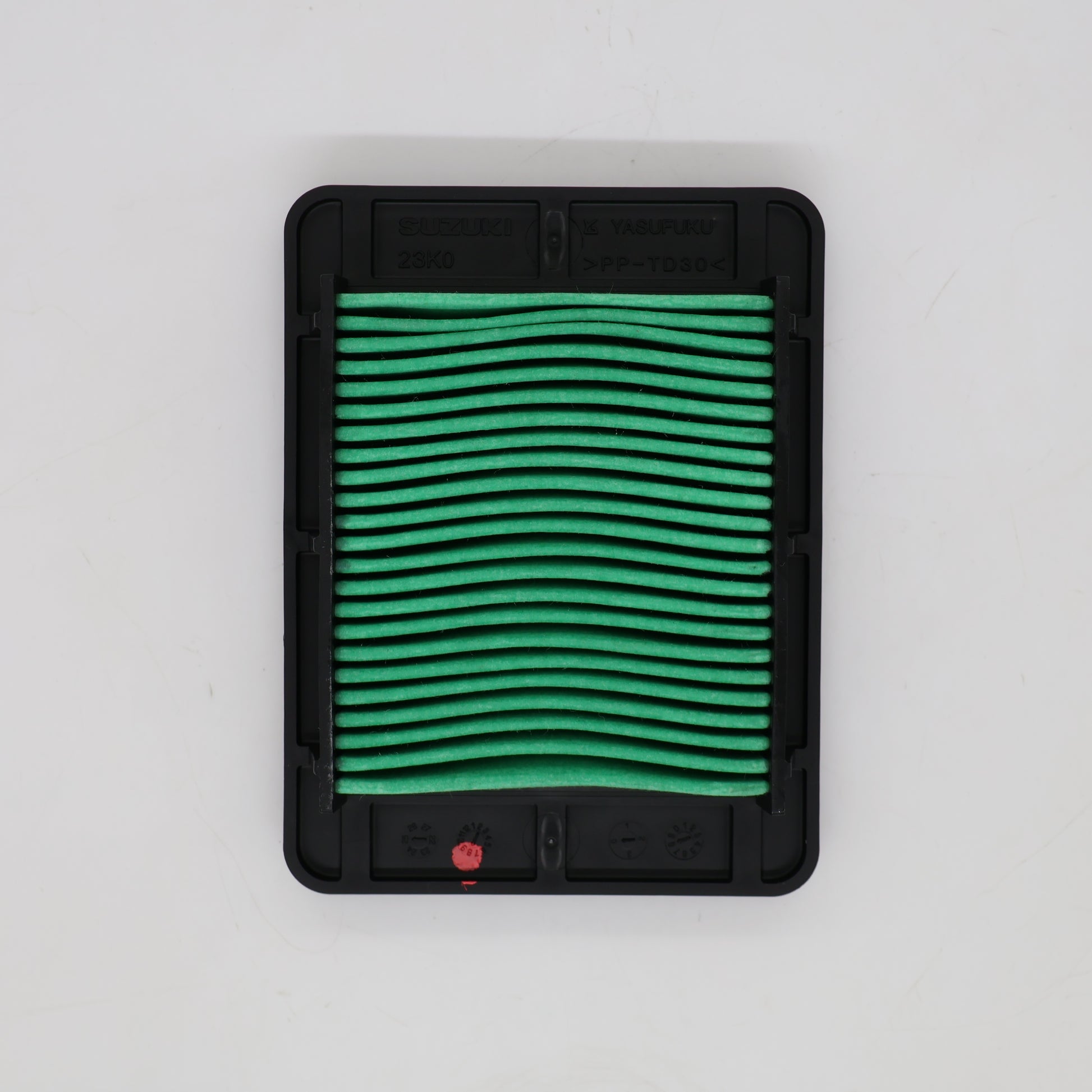 A rectangular automotive air filter with a black plastic frame and green pleated filter media, shown from a top-down view on a light gray background.