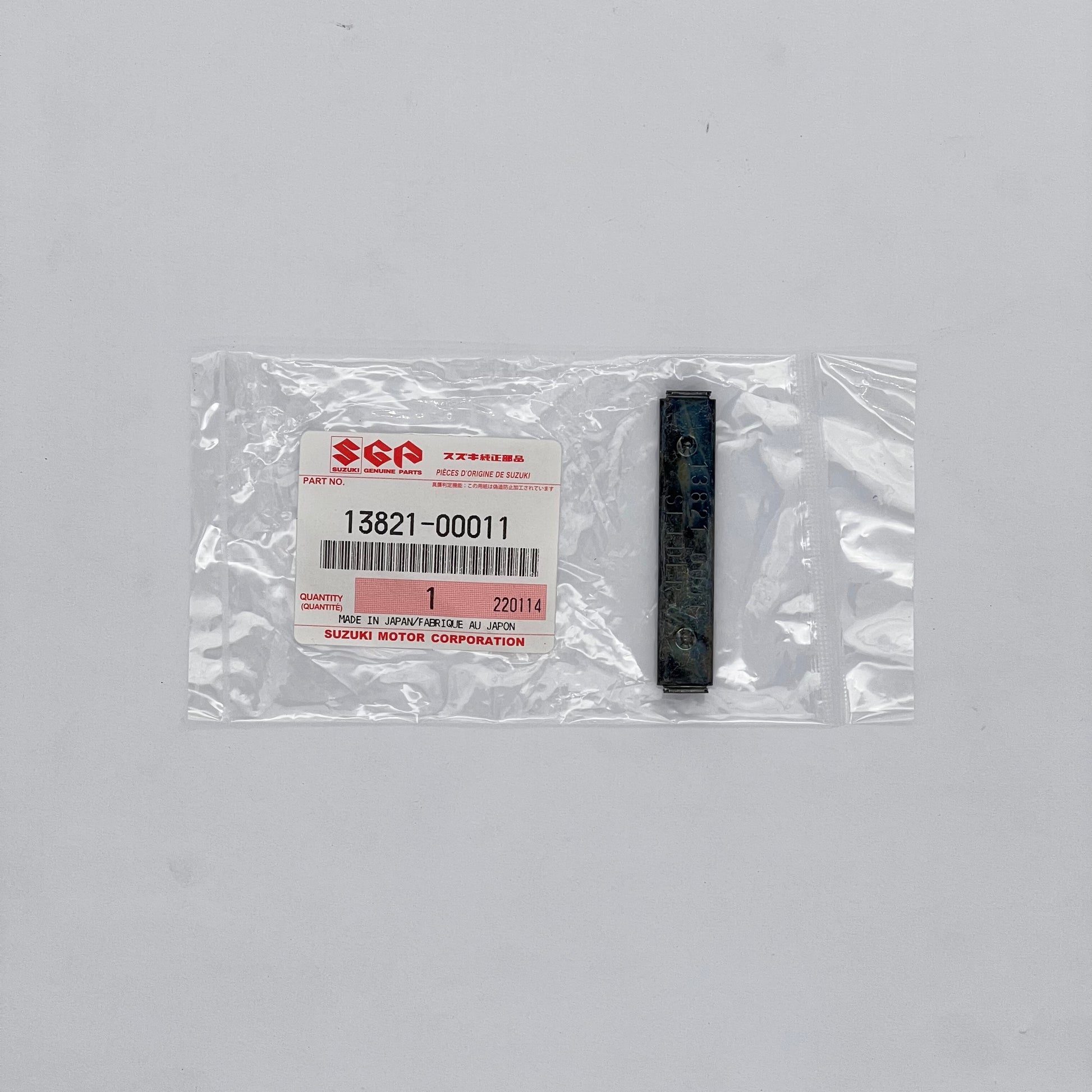 Suzuki part in packaging with a label on a gray background