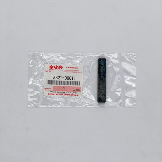 Suzuki part in packaging with a label on a gray background