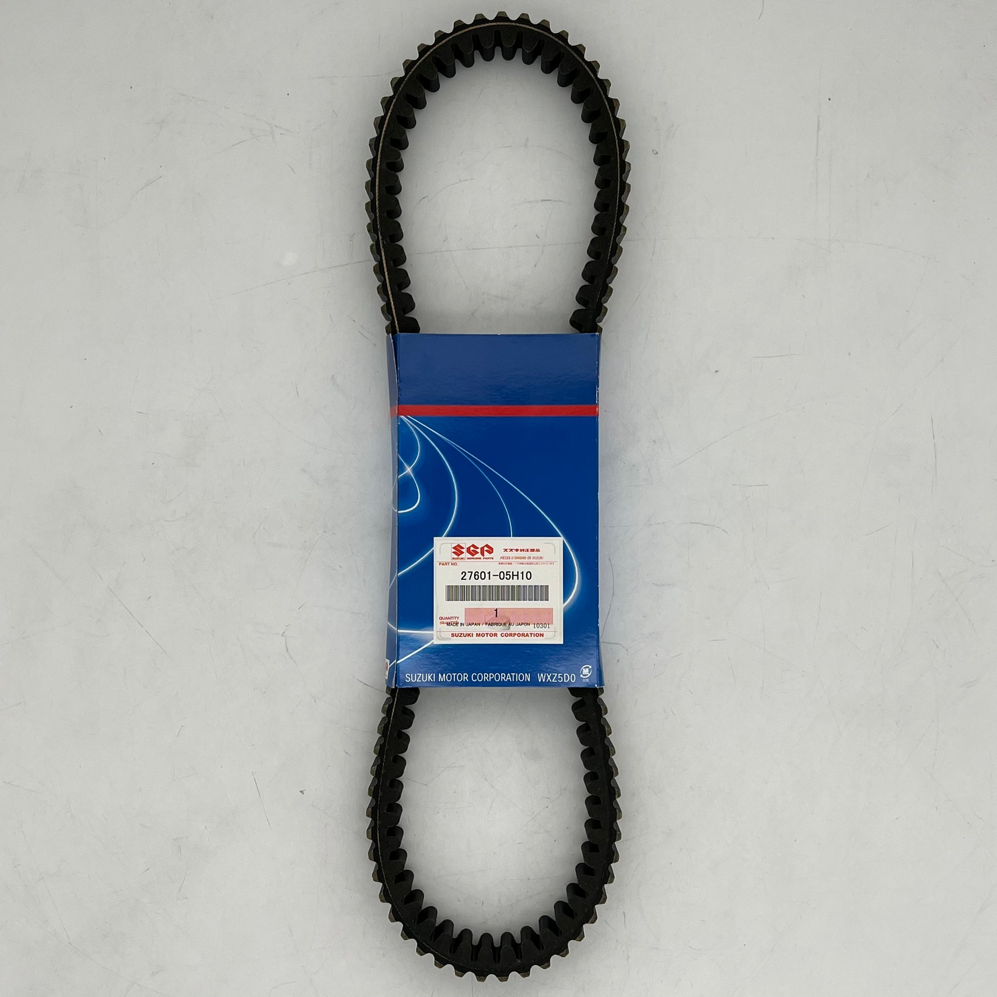 Black timing belt with a blue packaging label on a gray background