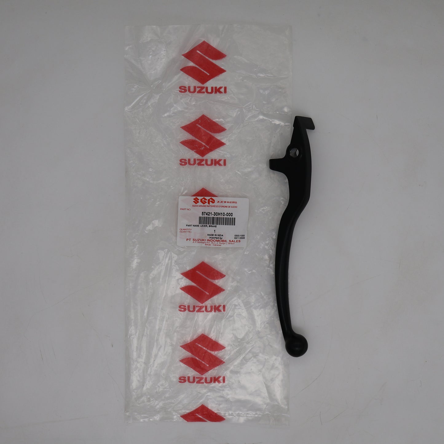 Black Suzuki motorcycle lever on a white background with clear packaging.